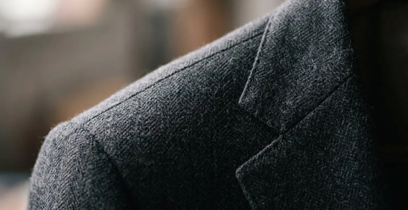 Macro detail of suit jacket shoulder construction showing canvas structure